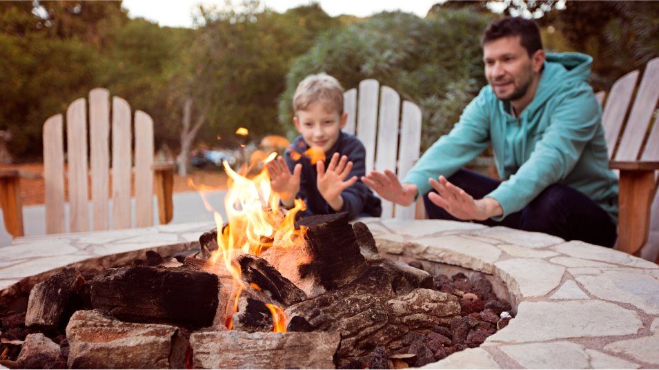 father and son sitting at campfire