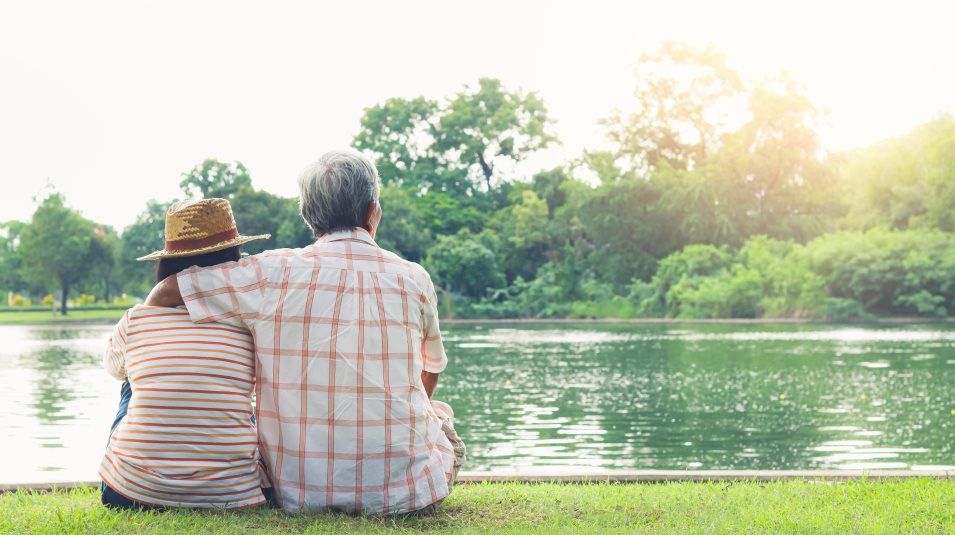Couple sitting next to pond