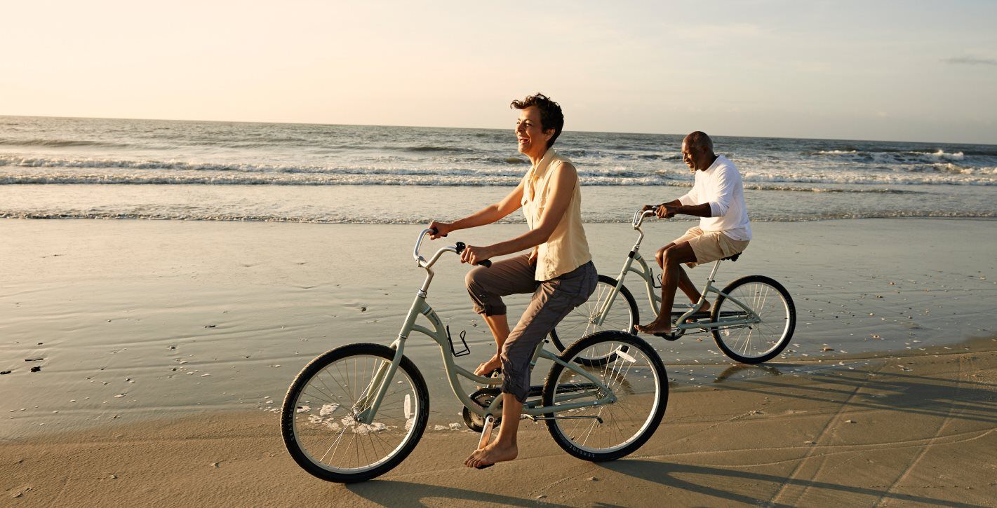 Couple riding bikes on beach
