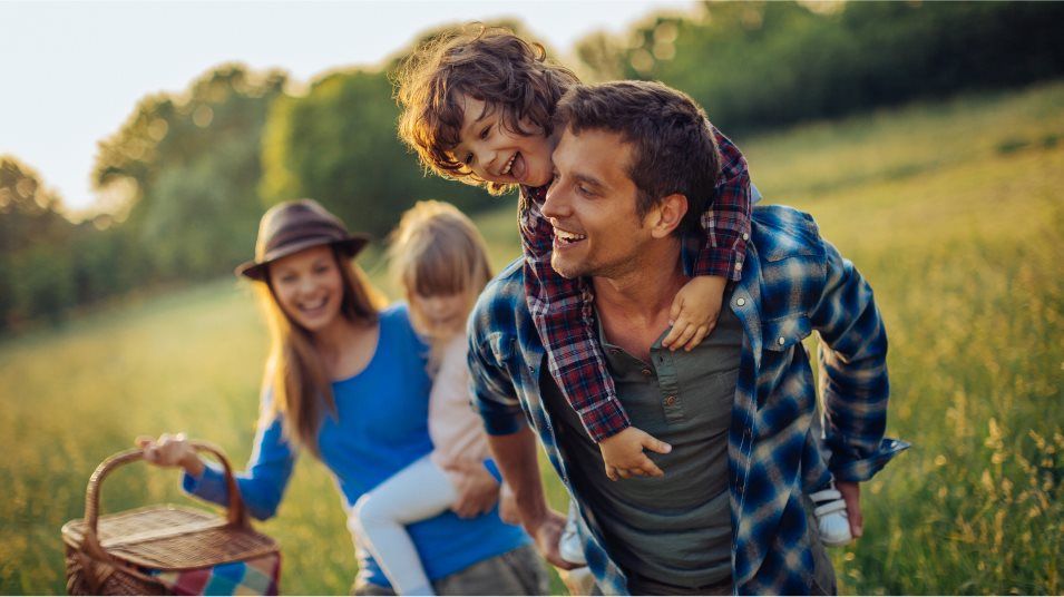 Family walking in field with picnic basket