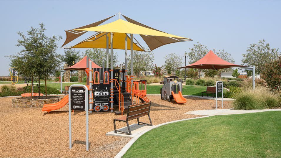 Tot lot structure in wood chips surrounded by grass