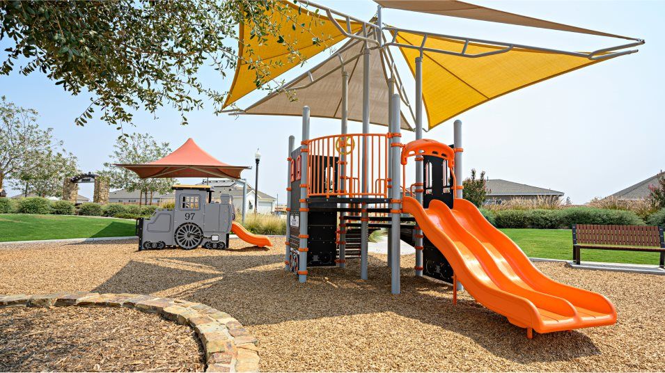 Tot lot structure in wood chips surrounded by grass