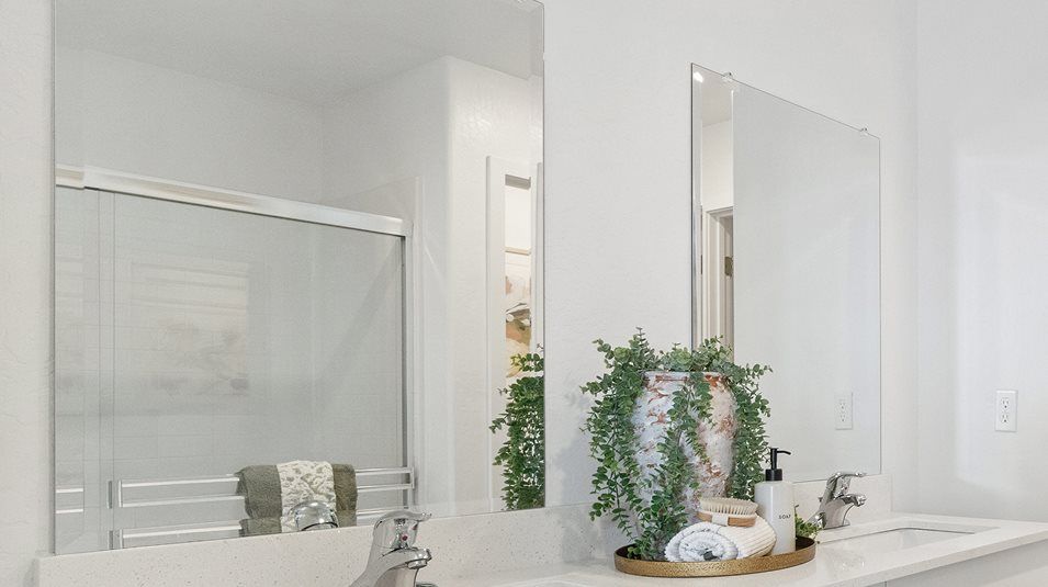 Glass vanity mirrors over each sink in the owner’s suite bathroom