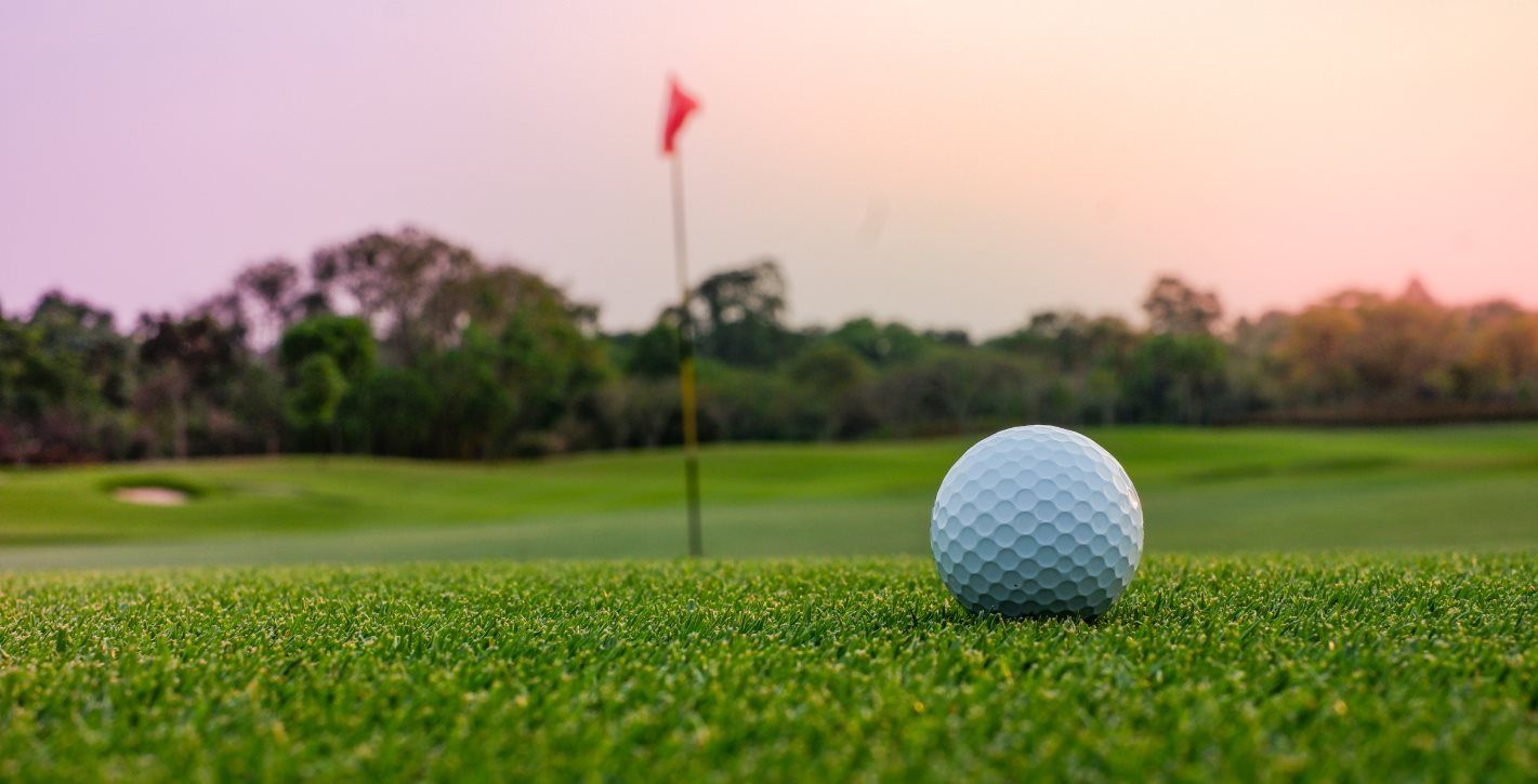 Golf ball on the green at sunset