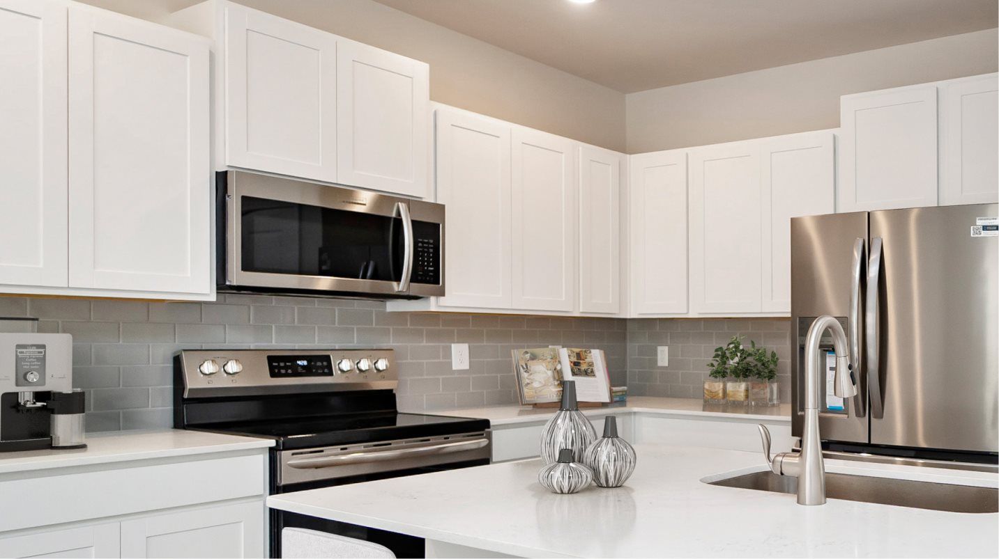 The kitchen features staggered-height cabinets to provide storage room and 9-foot ceilings