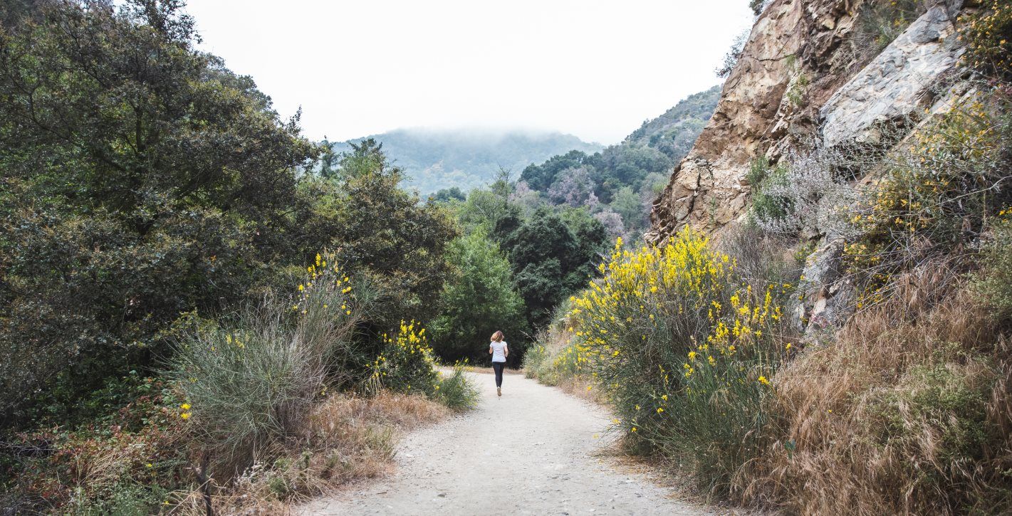 Woman running on a trail through angeles forest