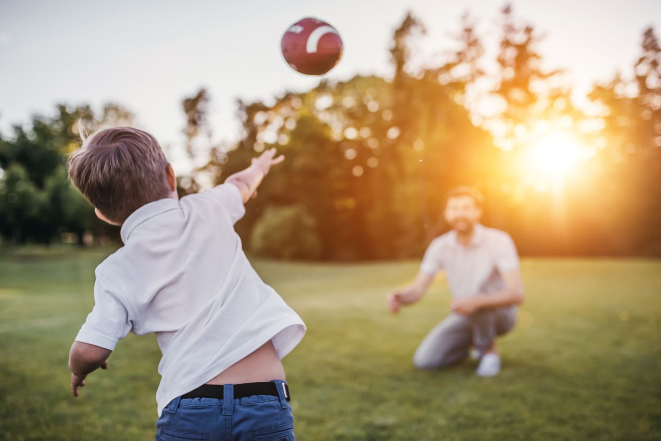 Father and son throw a football together.
