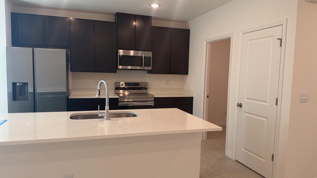 Mocha stained cabinets offer a great contrast with the quart