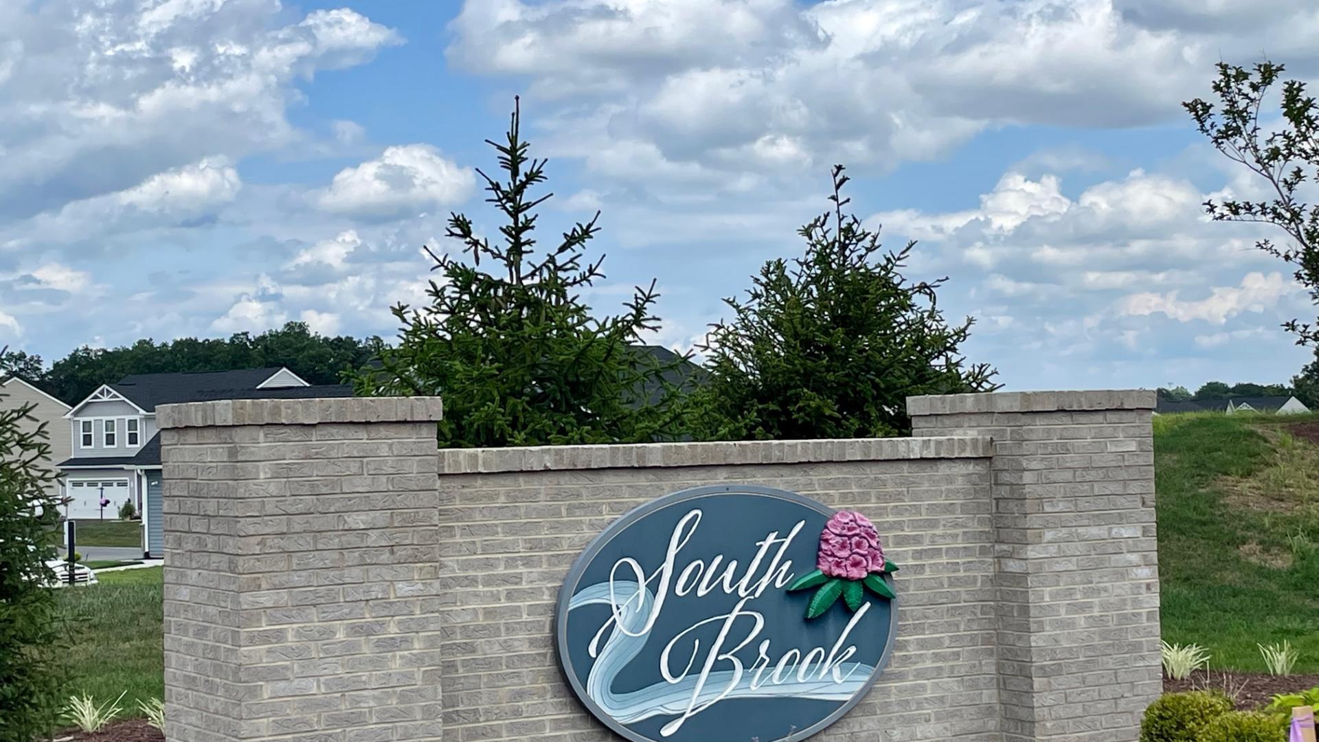 Beautifully landscaped community entrance and sidewalk-lined streets.