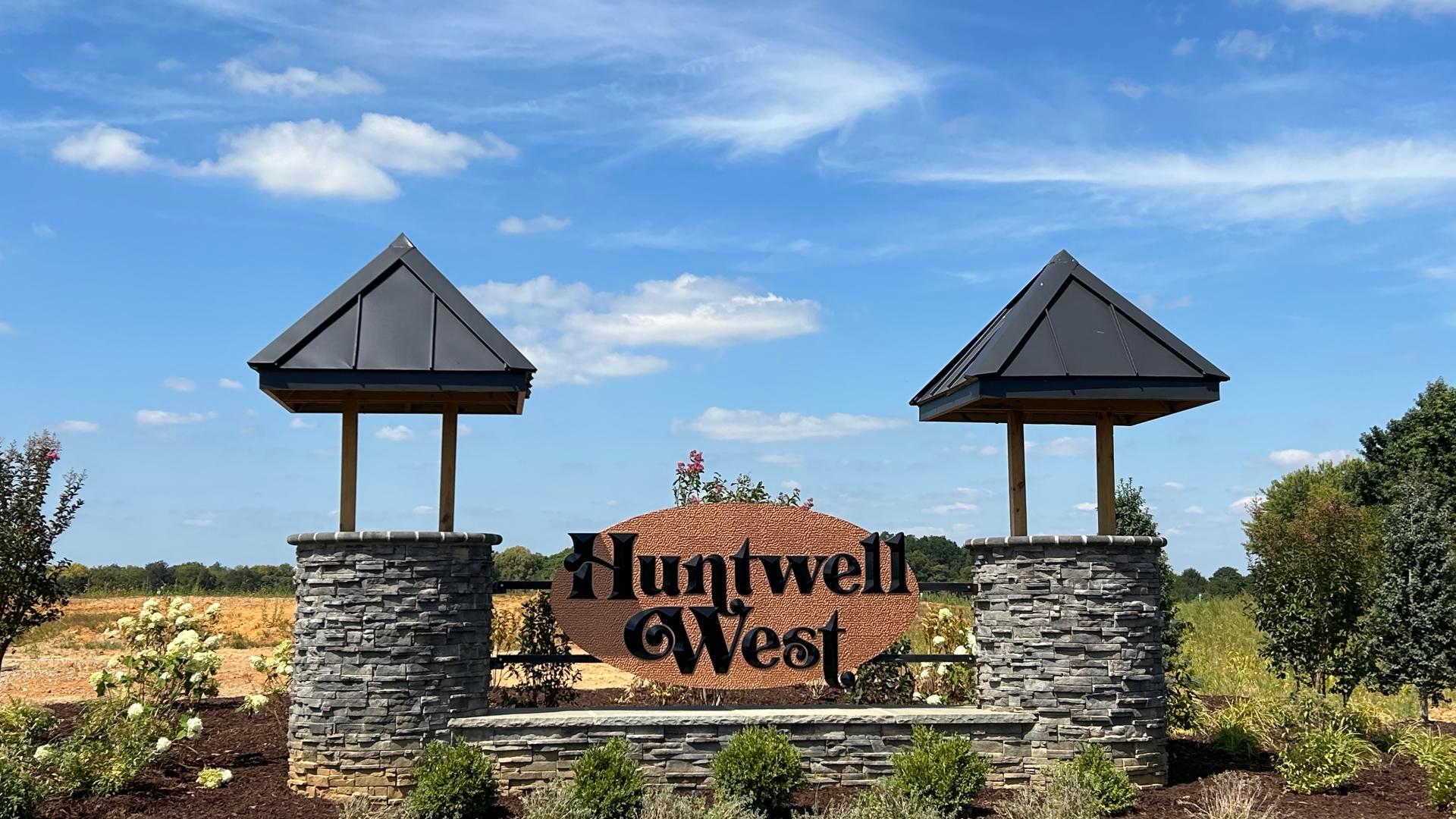 Beautifully landscaped community entrance and sidewalk-lined streets.