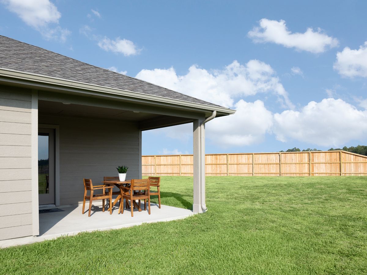 Relax in your backyard oasis under a covered patio.