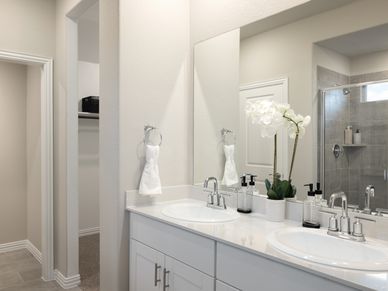 Your primary bathroom retreat features double vanities