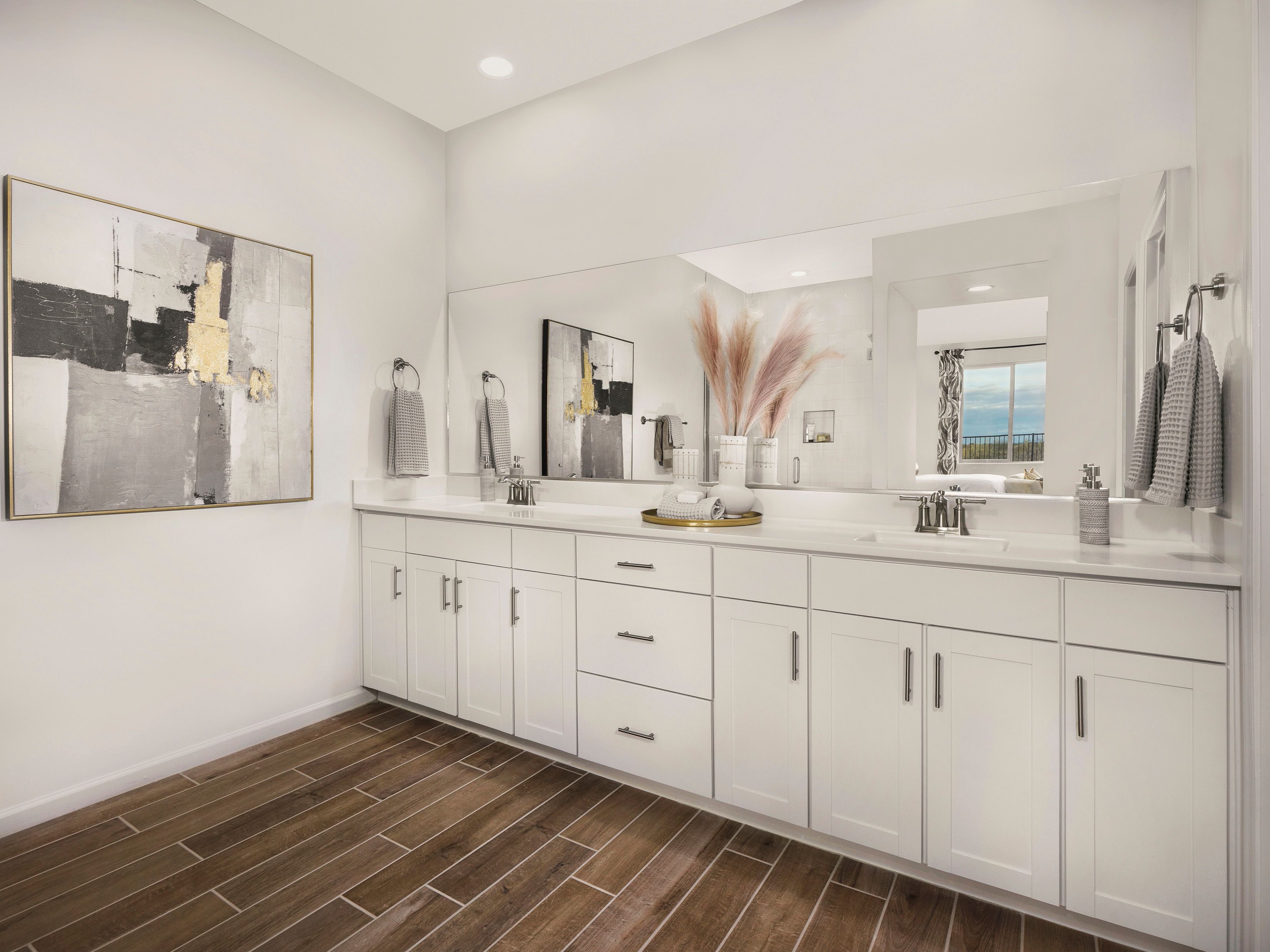 Getting ready is a breeze with dual vanities in the primary bathroom.