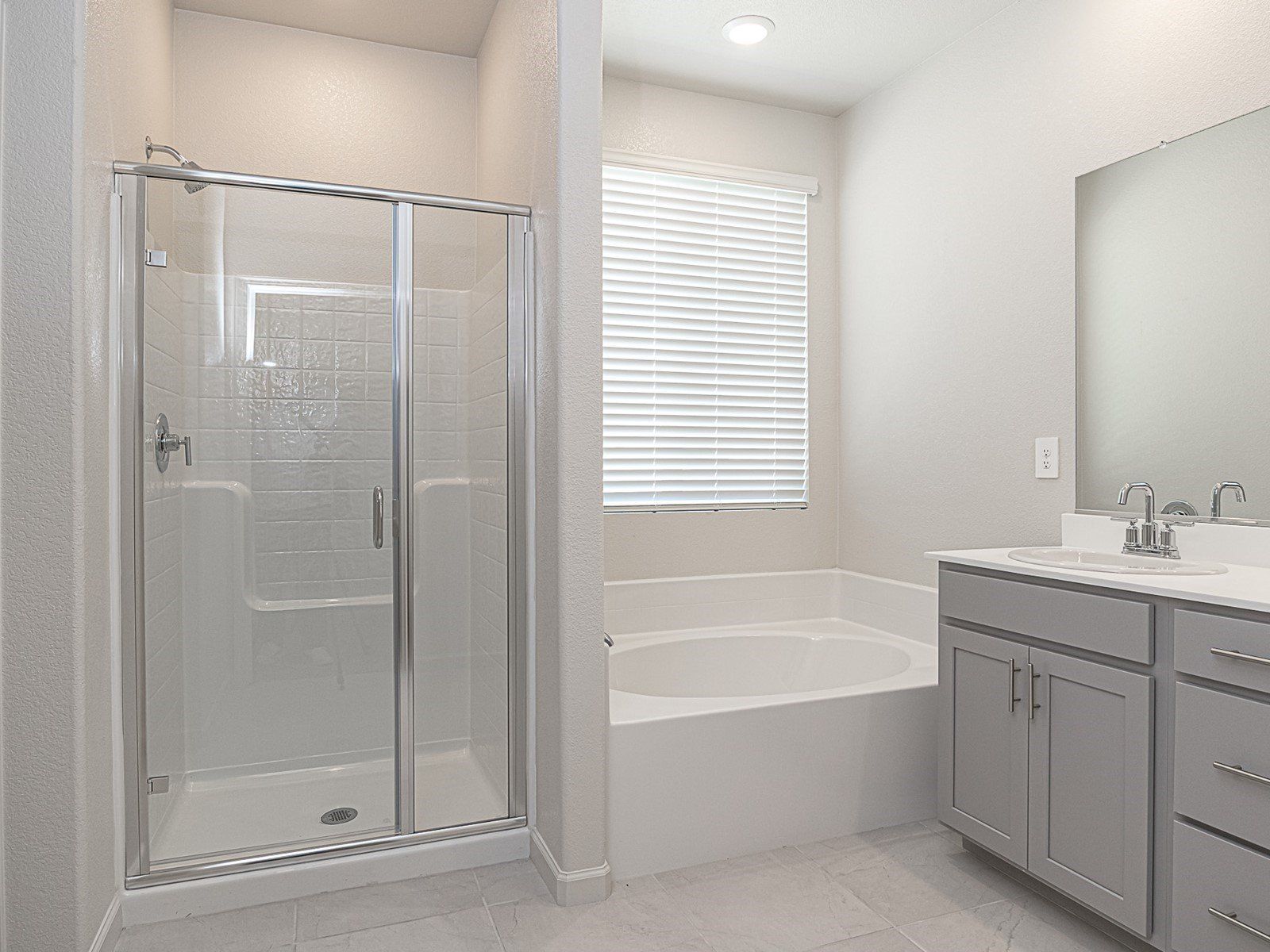 Primary bathroom with a duel sink vanity and stand alone bathtub.