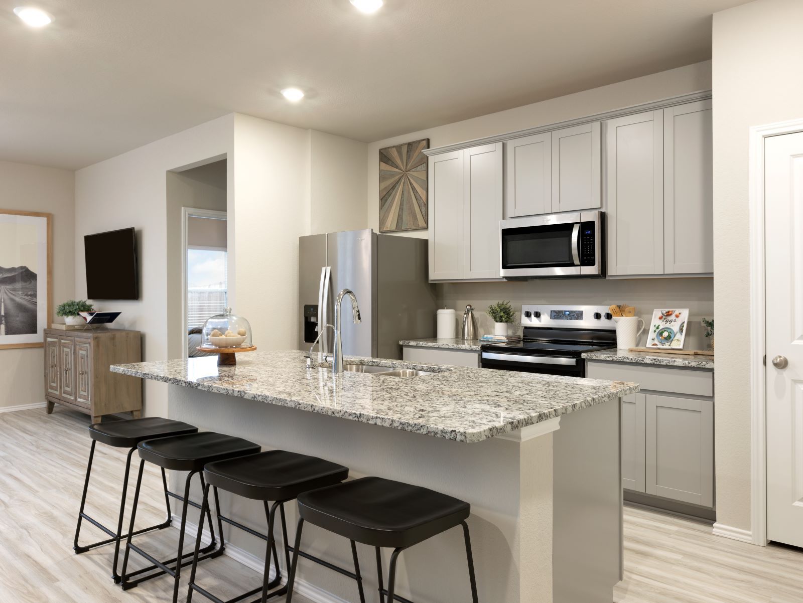 The Emma floorplan model kitchen features linen-colored cabinets and granite countertops.
