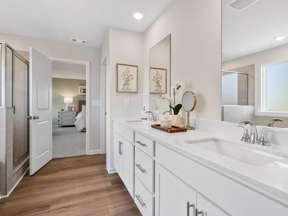 The primary bathroom boasts a dual-sink vanity, walk-in shower and oversized tub.