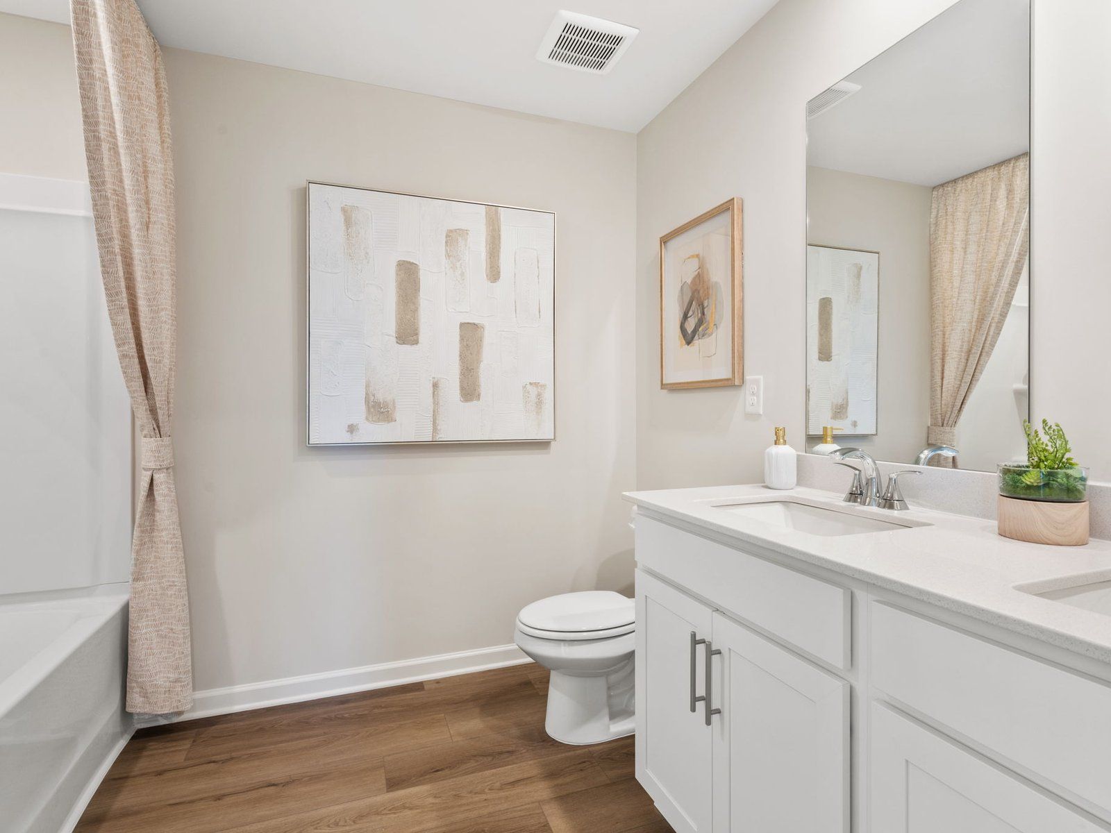 The secondary bathroom features a dual-sink vanity and oversized shower tub.
