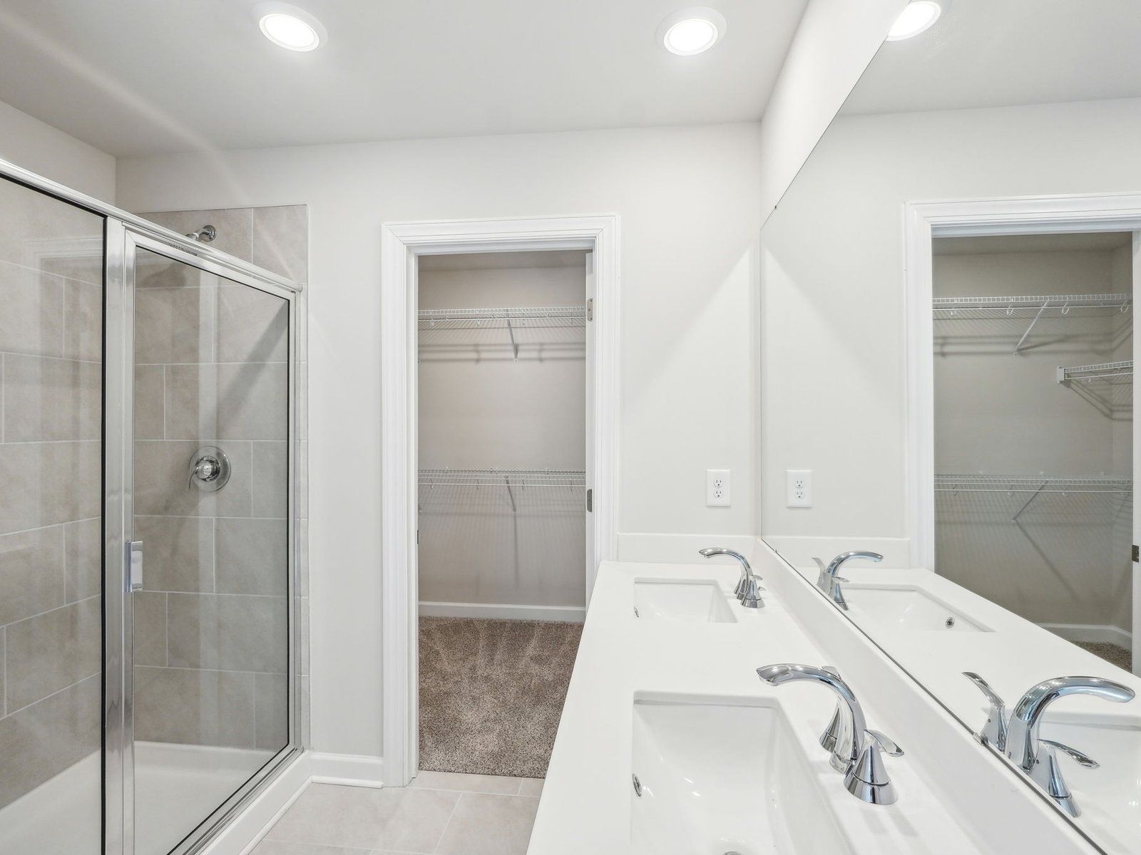 The primary bathroom boasts a dual-sink vanity and walk-in shower.