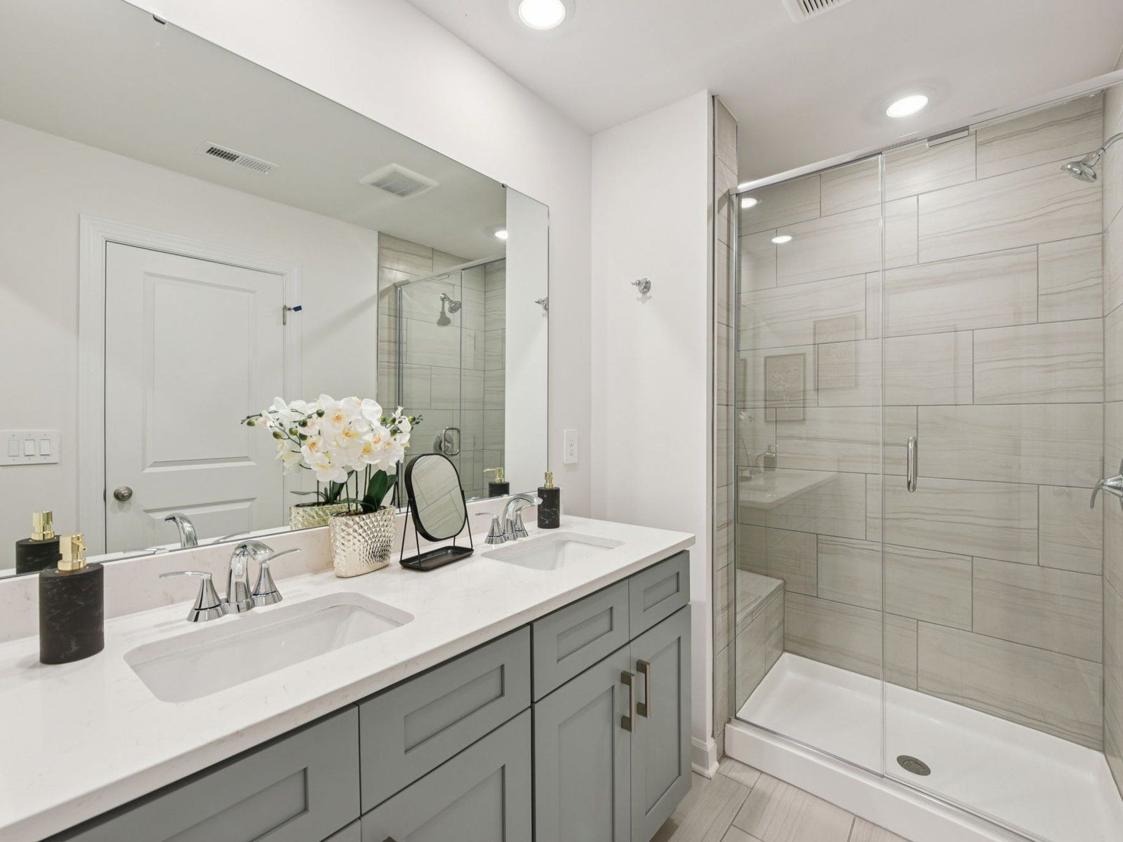 The primary bathroom boasts a dual-sink vanity and spacious walk-in shower.