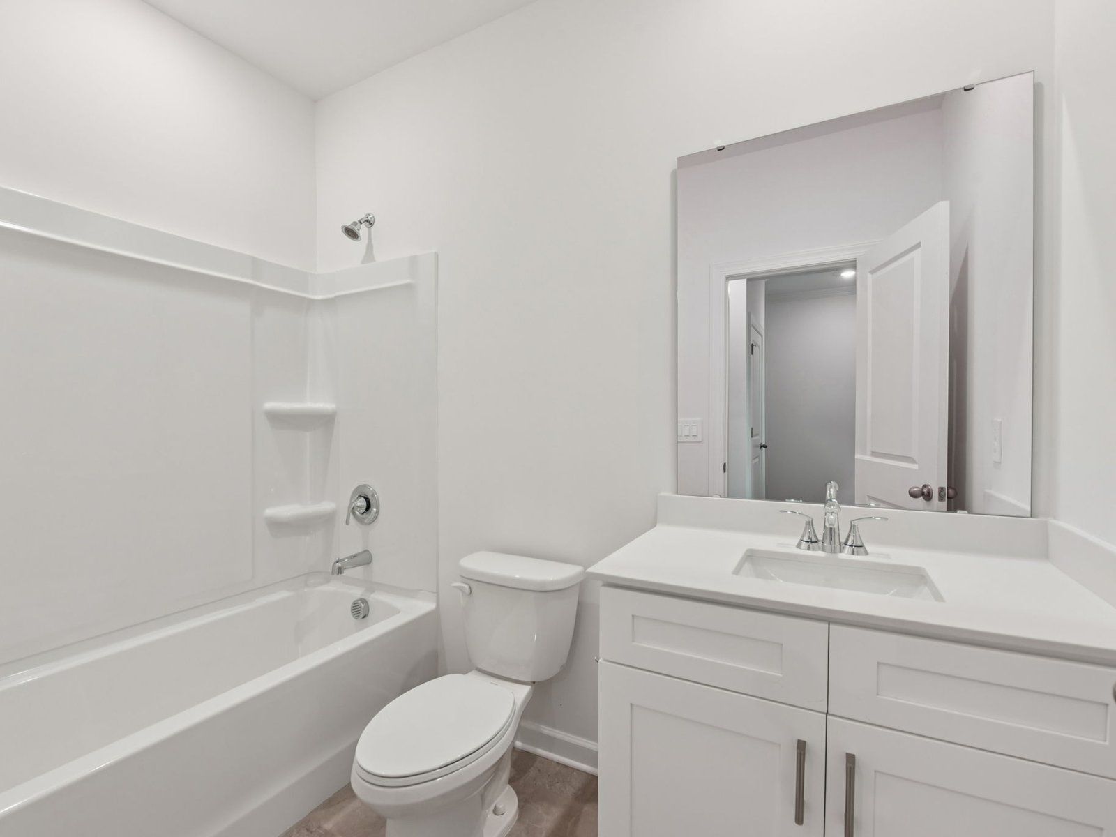 This secondary bathroom features an oversized shower tub and storage vanity.
