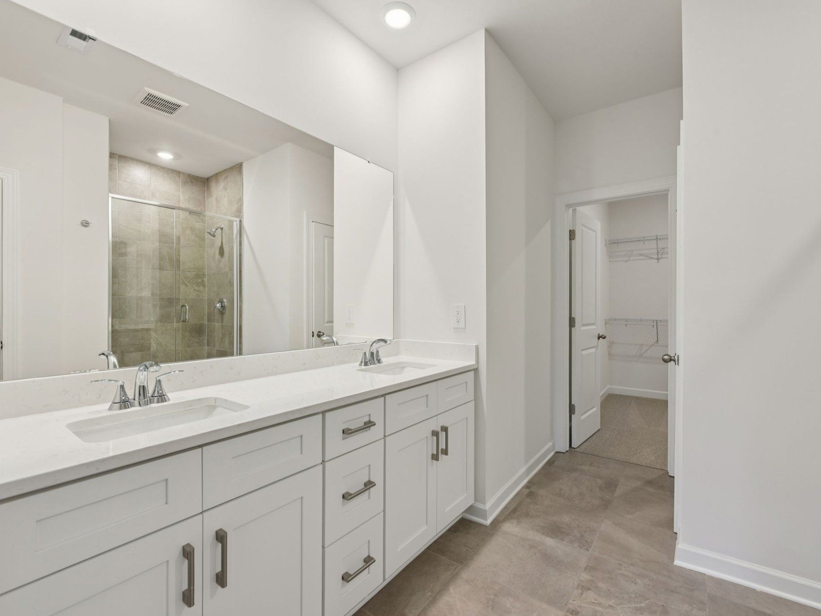 The primary bathroom boasts a spacious dual-sink vanity and walk-in shower.