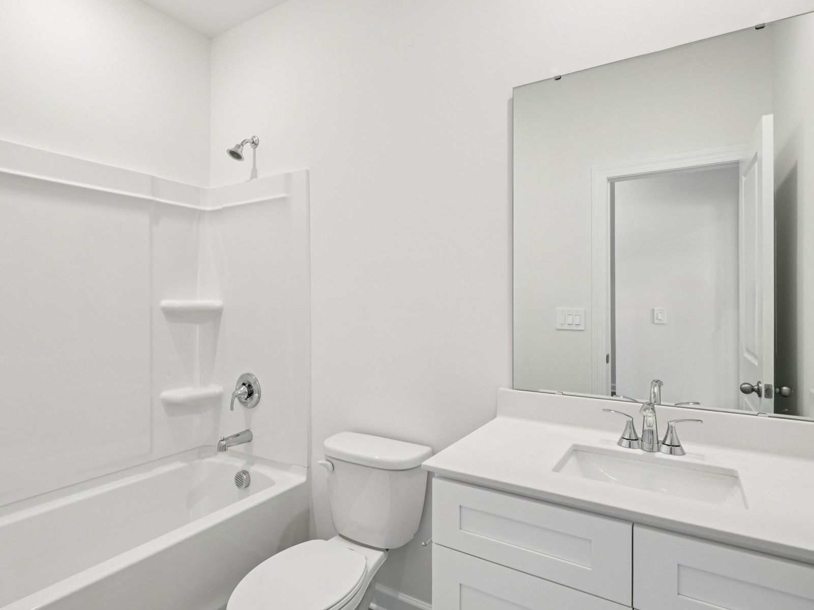 The secondary bathroom features a storage vanity and oversized shower tub.