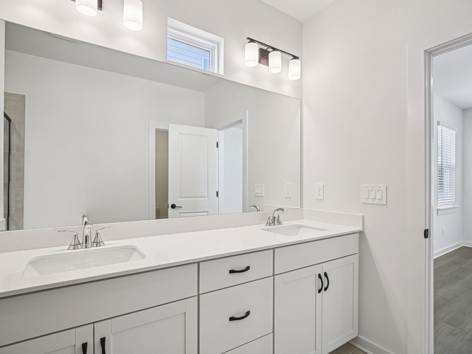 The primary bathroom offers dual vanity sinks and a walk-in shower.