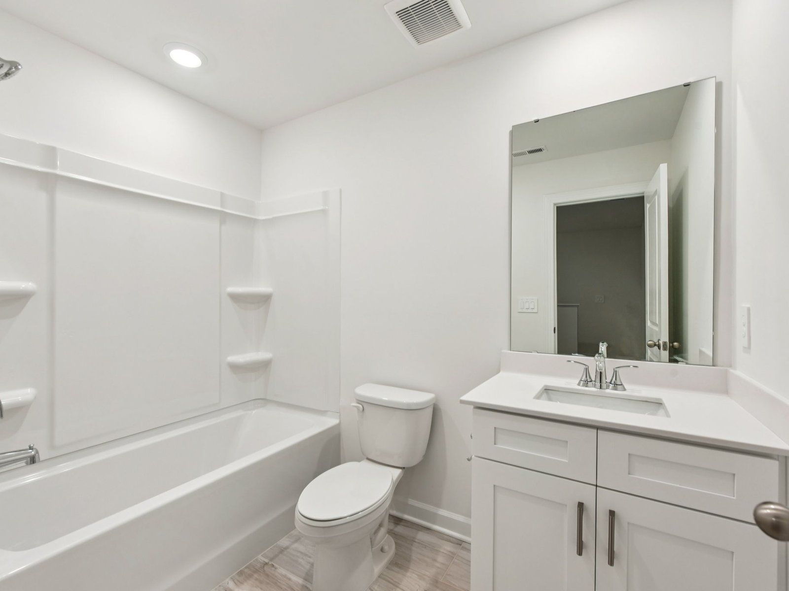 The secondary bathroom features a storage vanity and oversized shower tub.