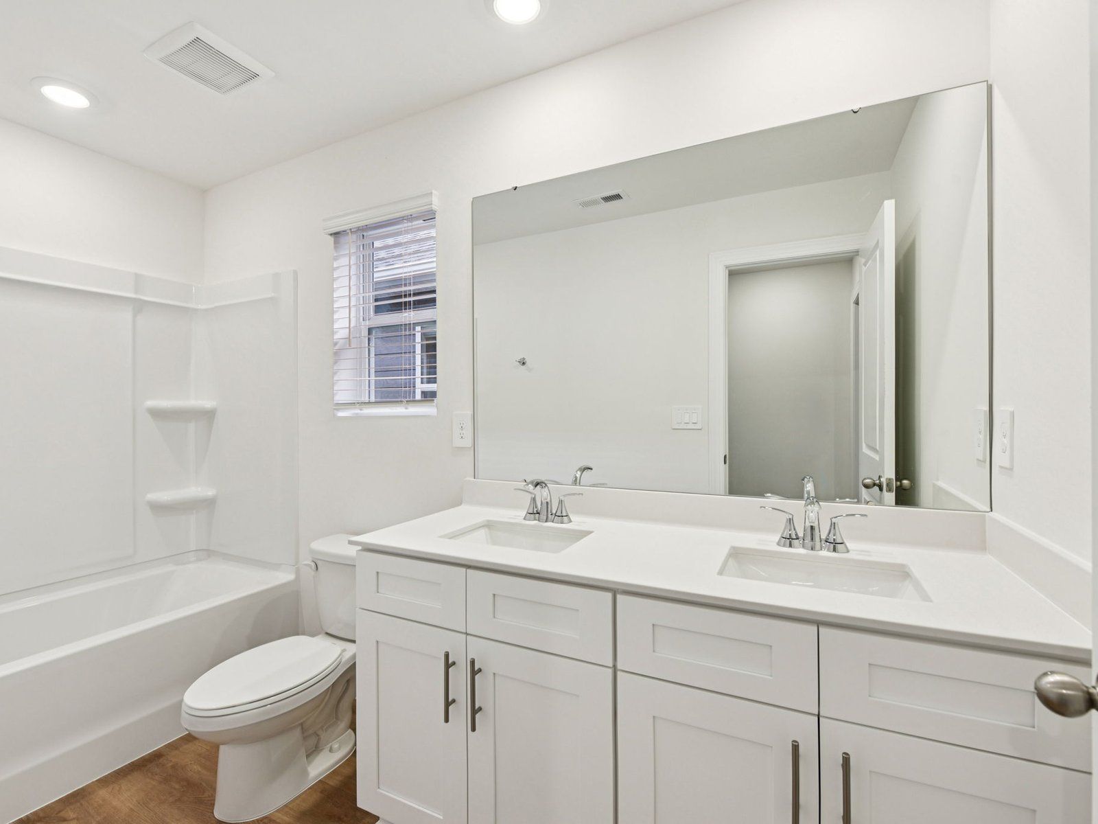 The secondary bathroom features a dual-sink vanity and oversized shower tub.