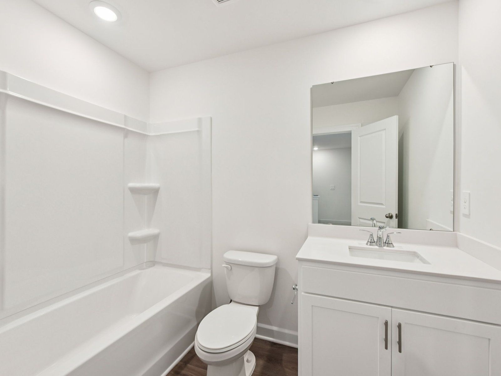The secondary bathroom features a storage vanity and oversized shower tub.