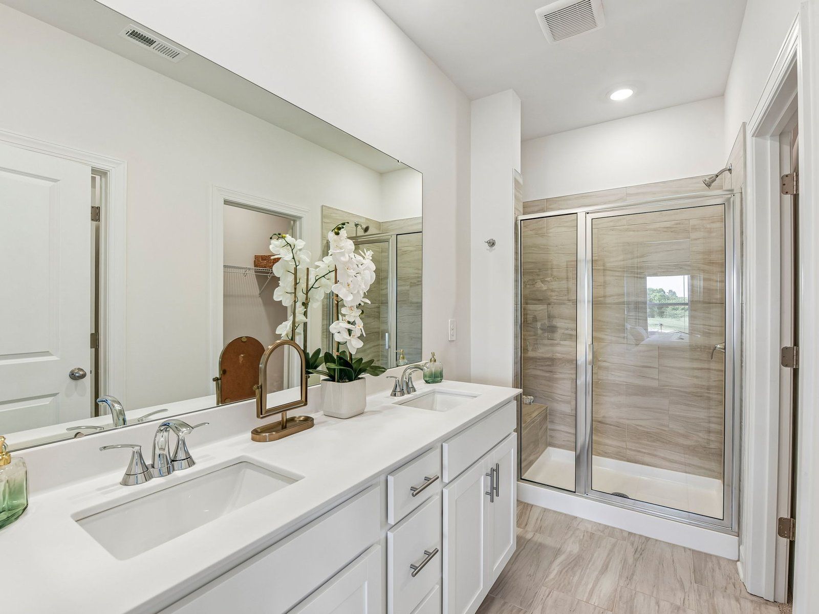 The primary bathroom boasts a dual-sink vanity and modern walk-in shower.
