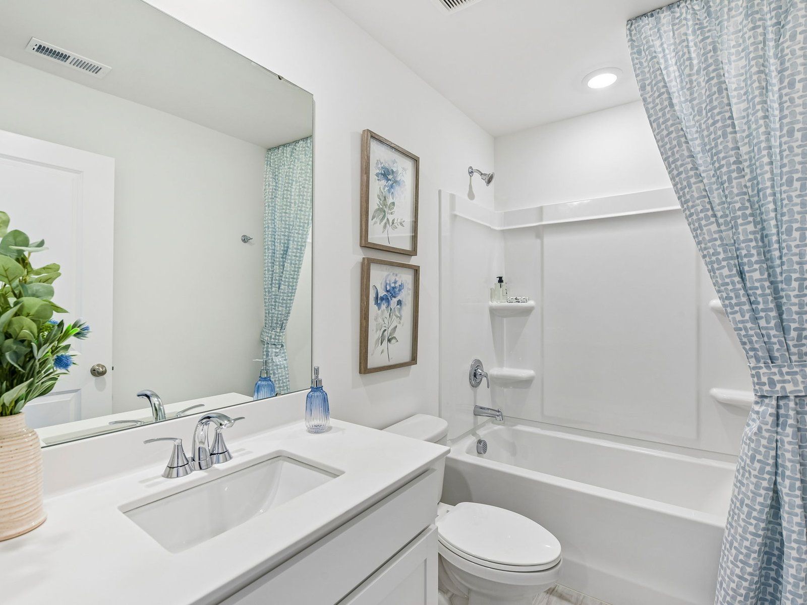 The secondary bathroom features a storage vanity and oversized shower tub.