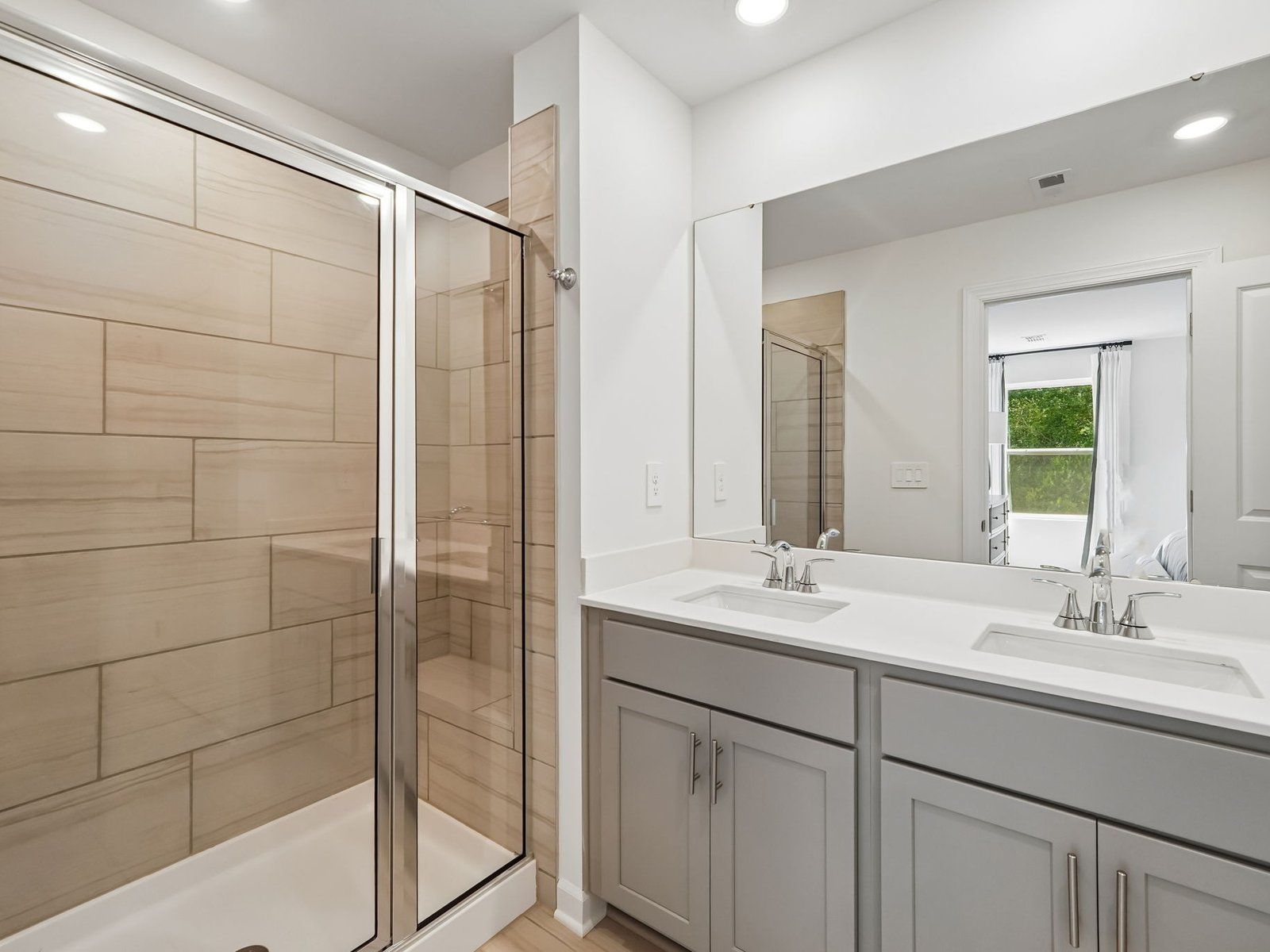 The primary bathroom boasts a dual-sink vanity and spacious walk-in shower.