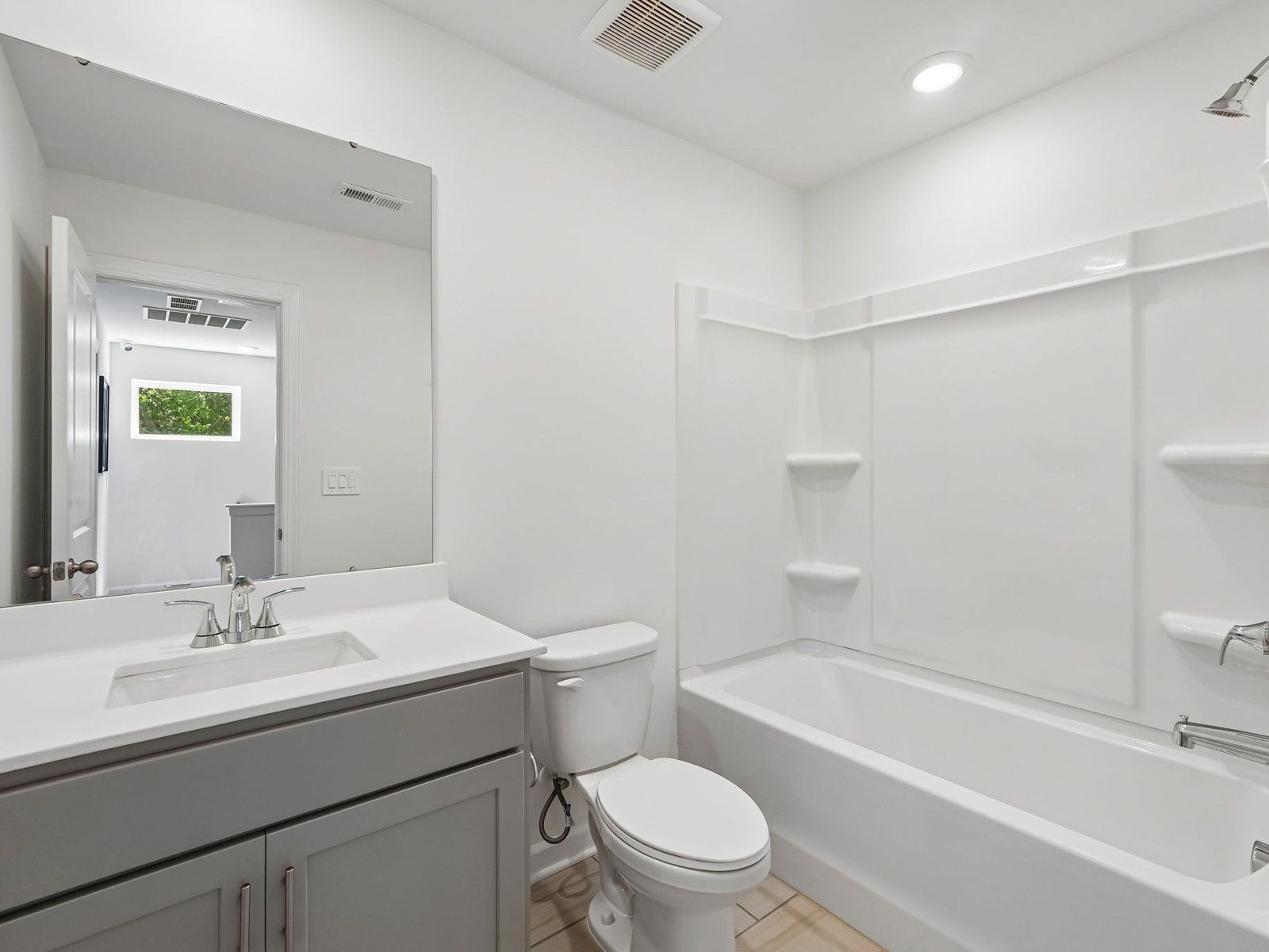 The secondary bathroom features a storage vanity and oversized shower tub.