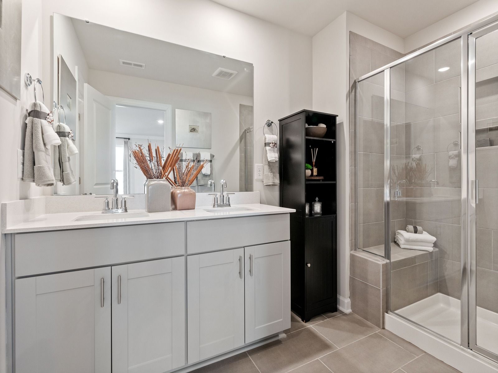 The primary bathroom boasts a dual-sink vanity and modern walk-in shower.