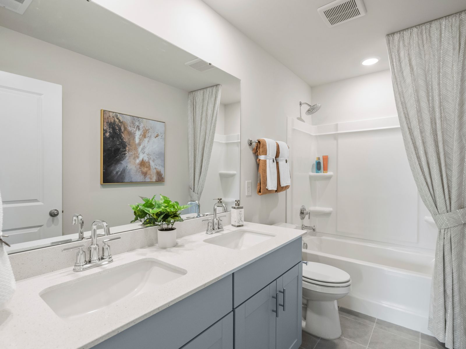 The secondary bathroom offers dual sinks and plenty of space for family and guests.