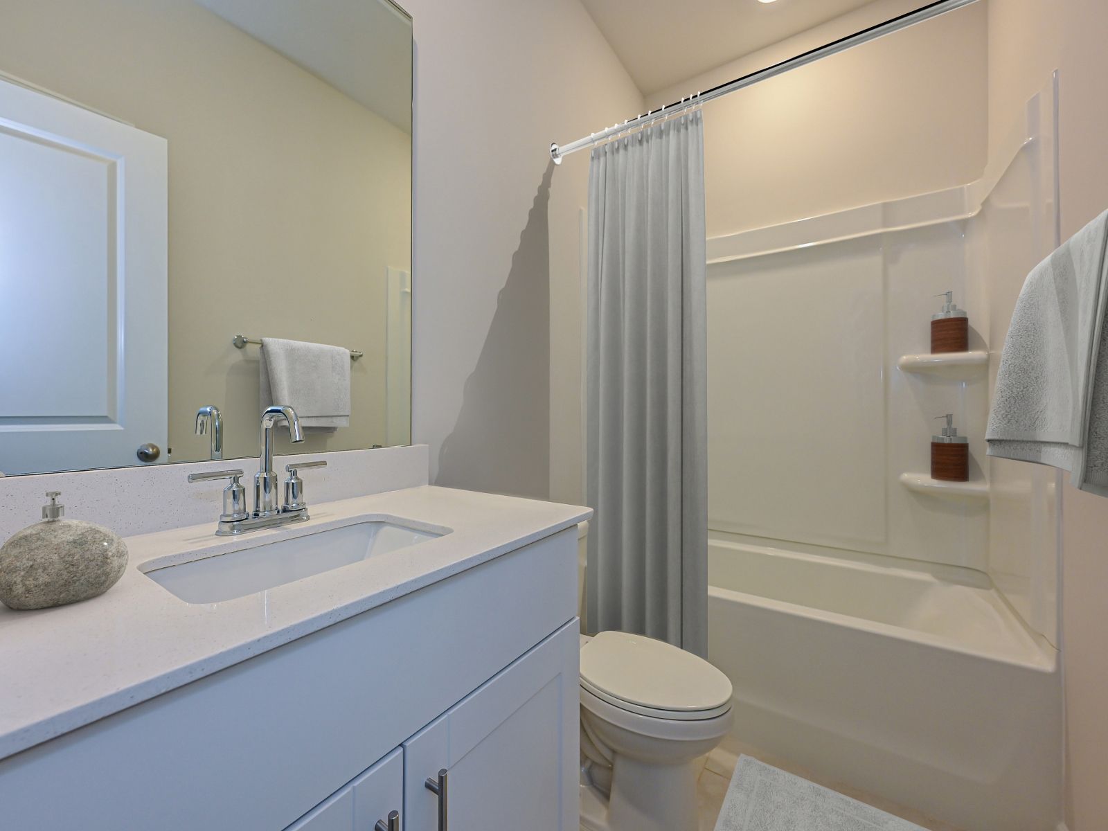 The secondary bathroom with a spacious vanity and tub.