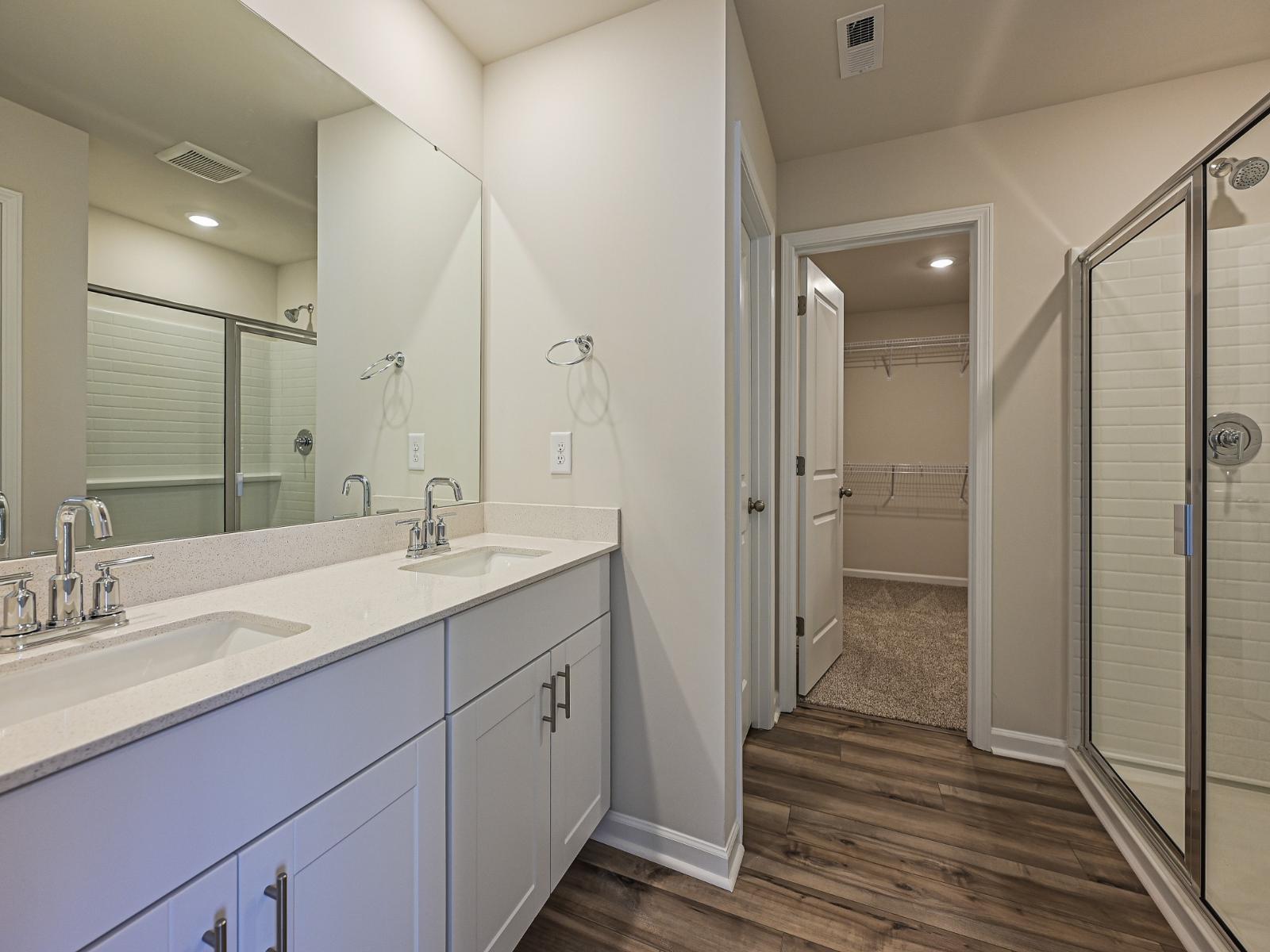 The primary bathroom with a walk-in shower and oversized closet.