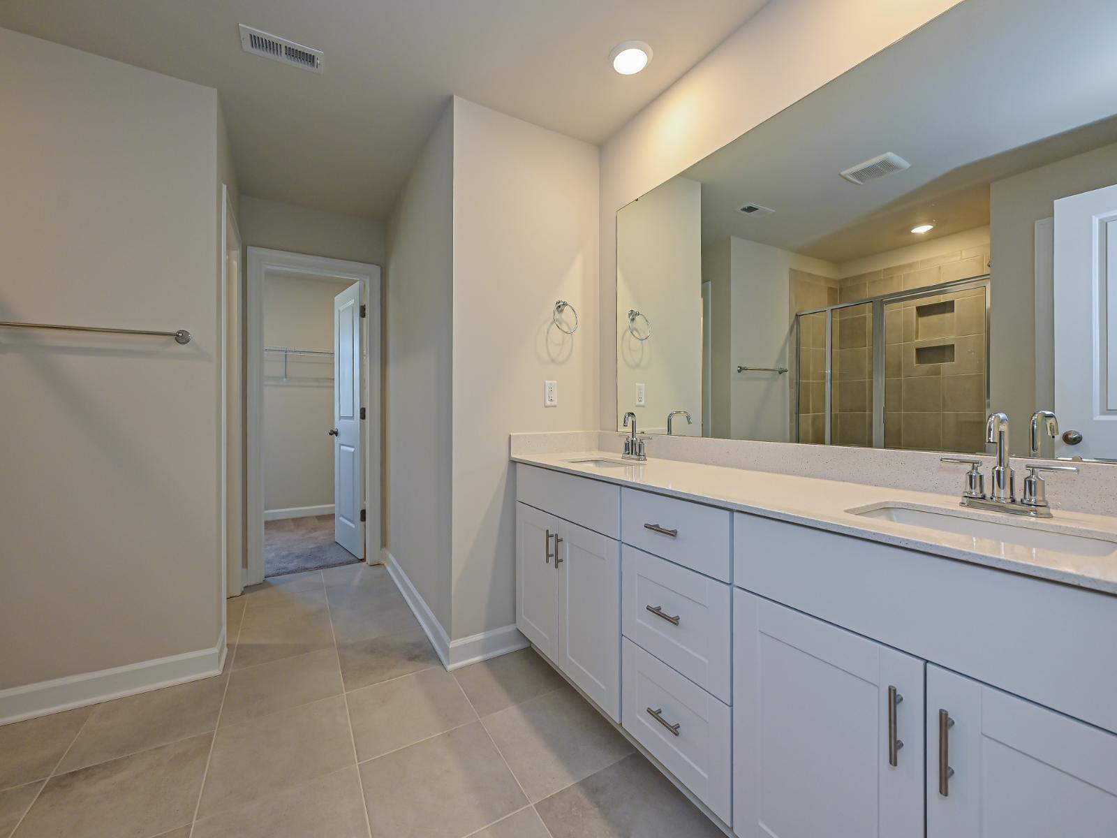 The primary bathroom features dual sinks and a walk-in closet.