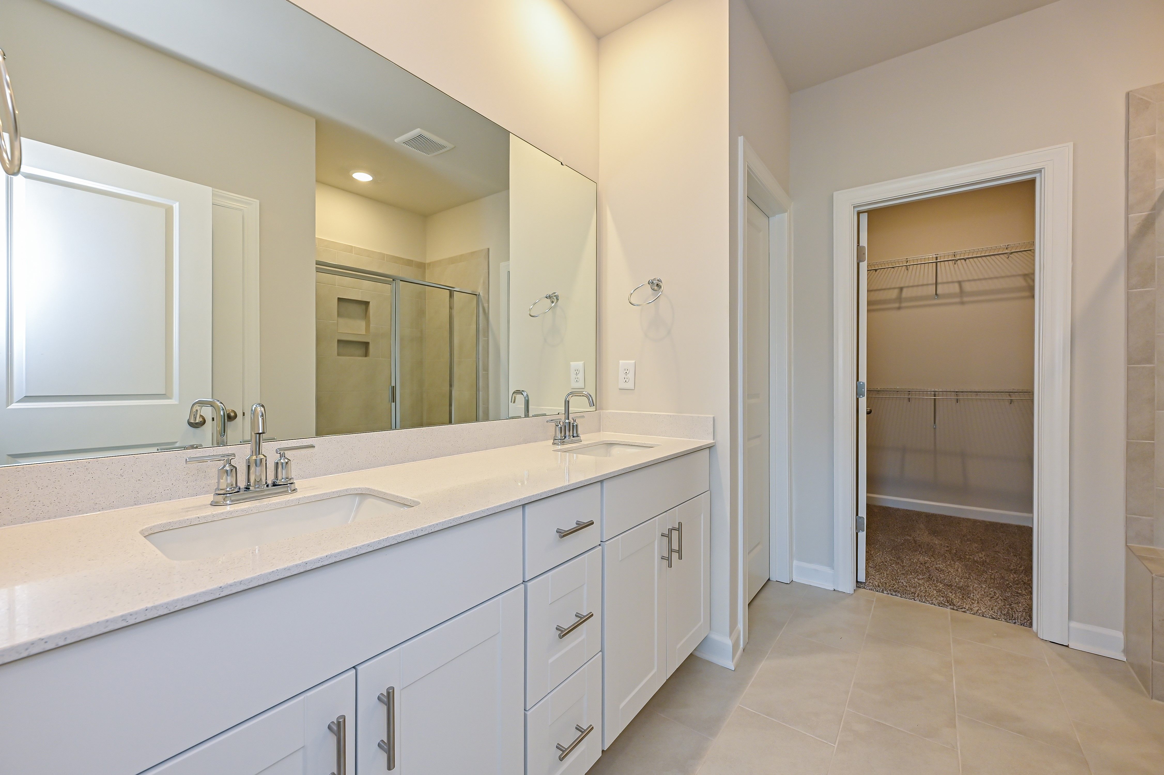 The spacious primary bathroom features a double-sink vanity and an oversized closet.