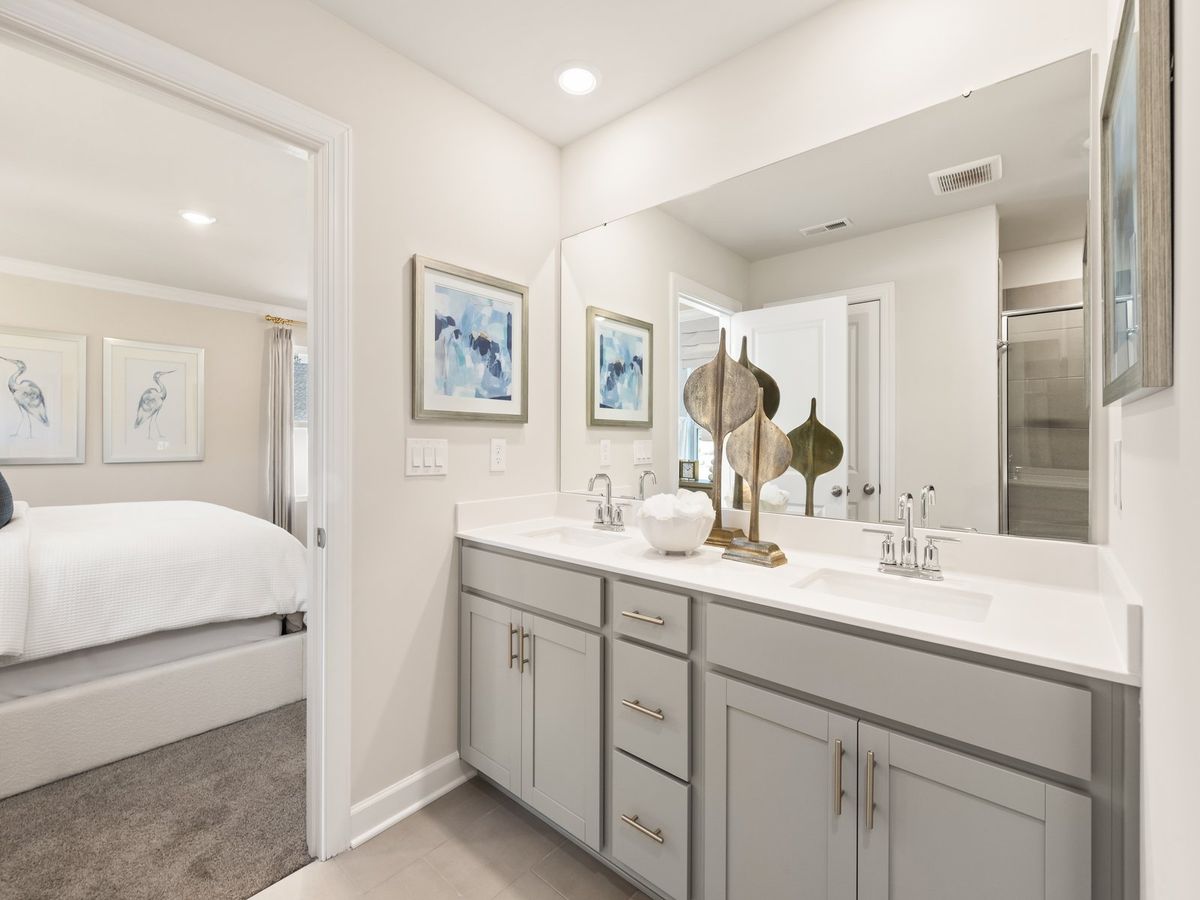 The ensuite bathroom features dual-vanity sinks and a walk-in closet.