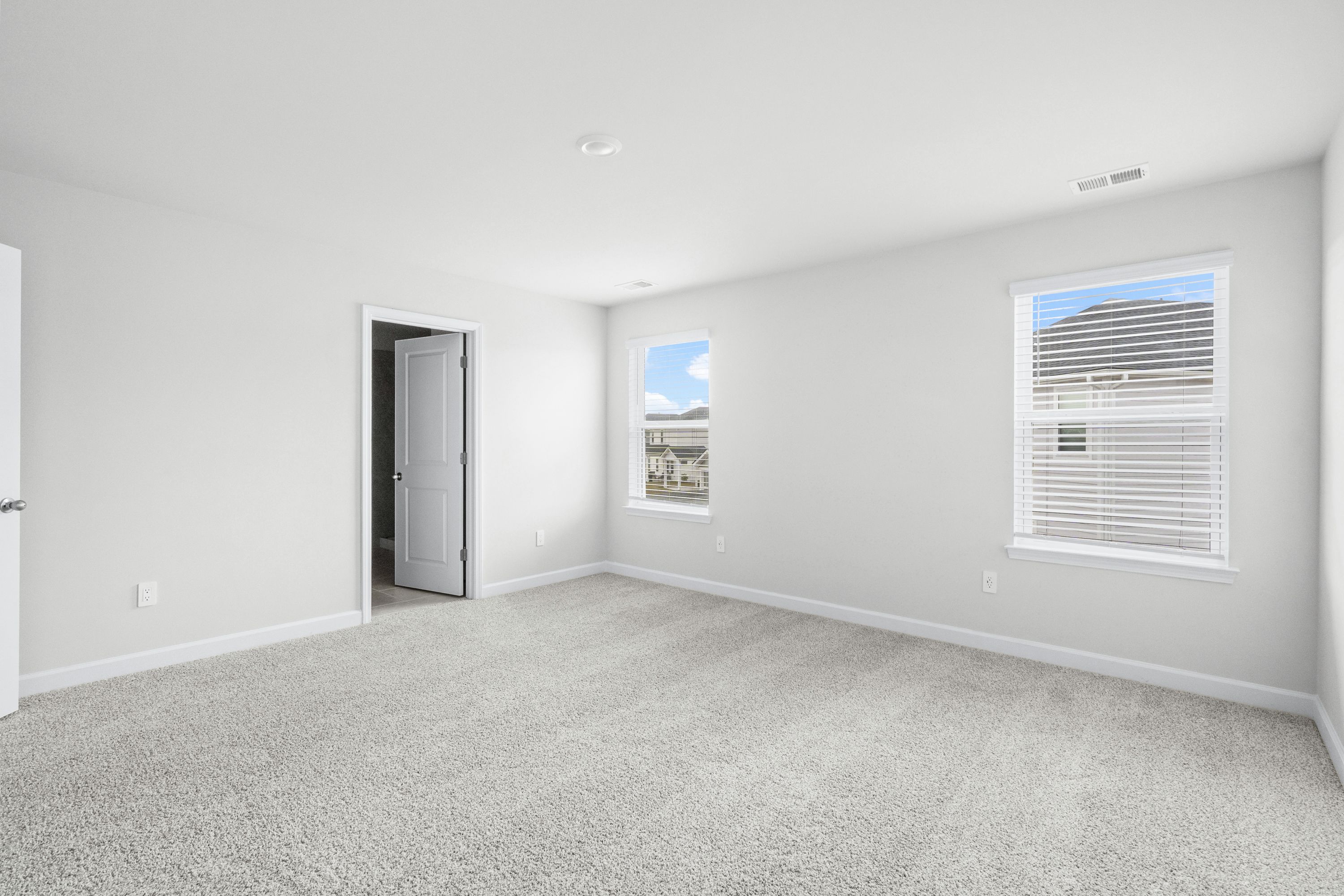 Relax and recharge in the spacious, light-filled primary suite.
