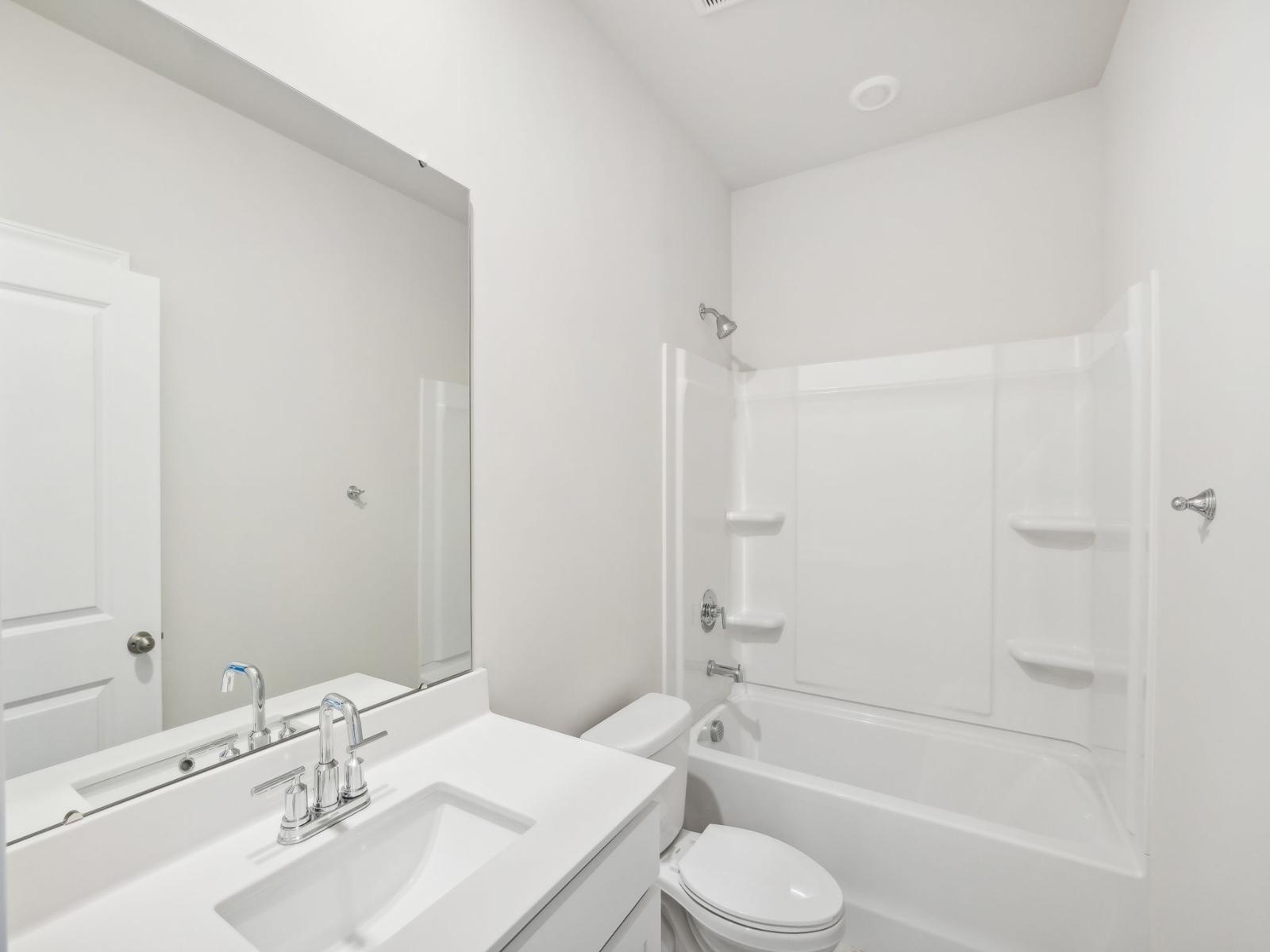 The secondary bathroom with a large vanity and oversized tub.