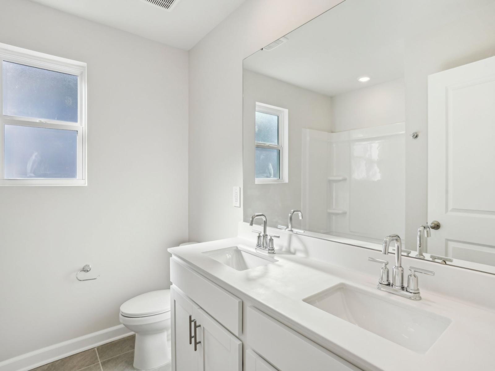 Your secondary bathroom with a shower tub and double-sink vanity.