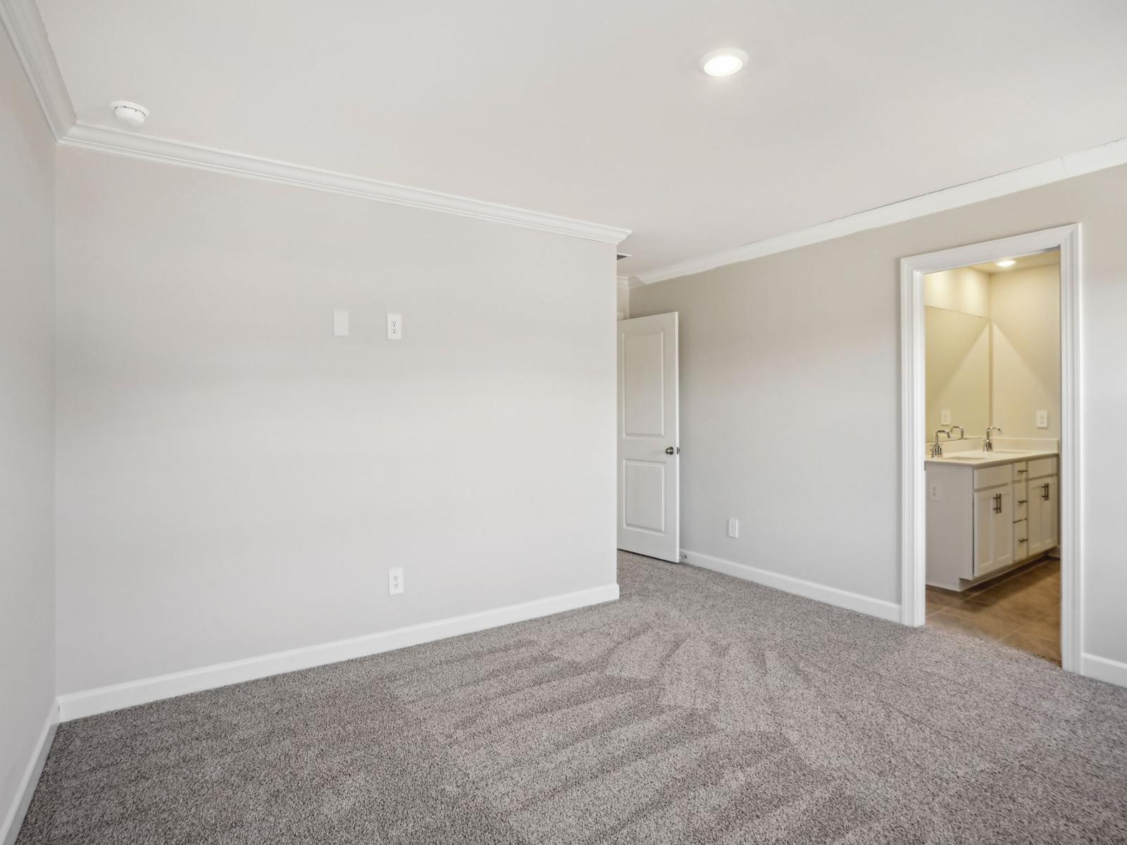 The primary suite with natural light and a connecting full bathroom.