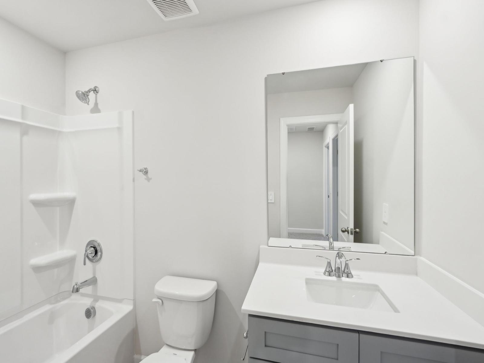 The secondary bedroom features an oversized tub and modern vanity.