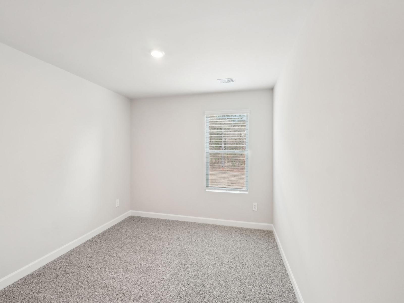 This secondary bedroom is perfect for a small home gym or for hosting guests.