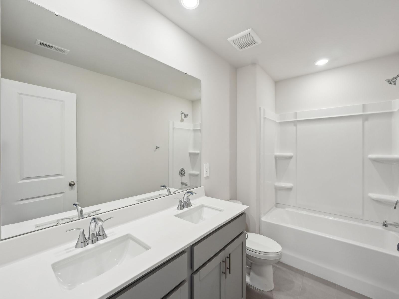 The secondary bathroom features a double-sink vanity and oversized shower tub.