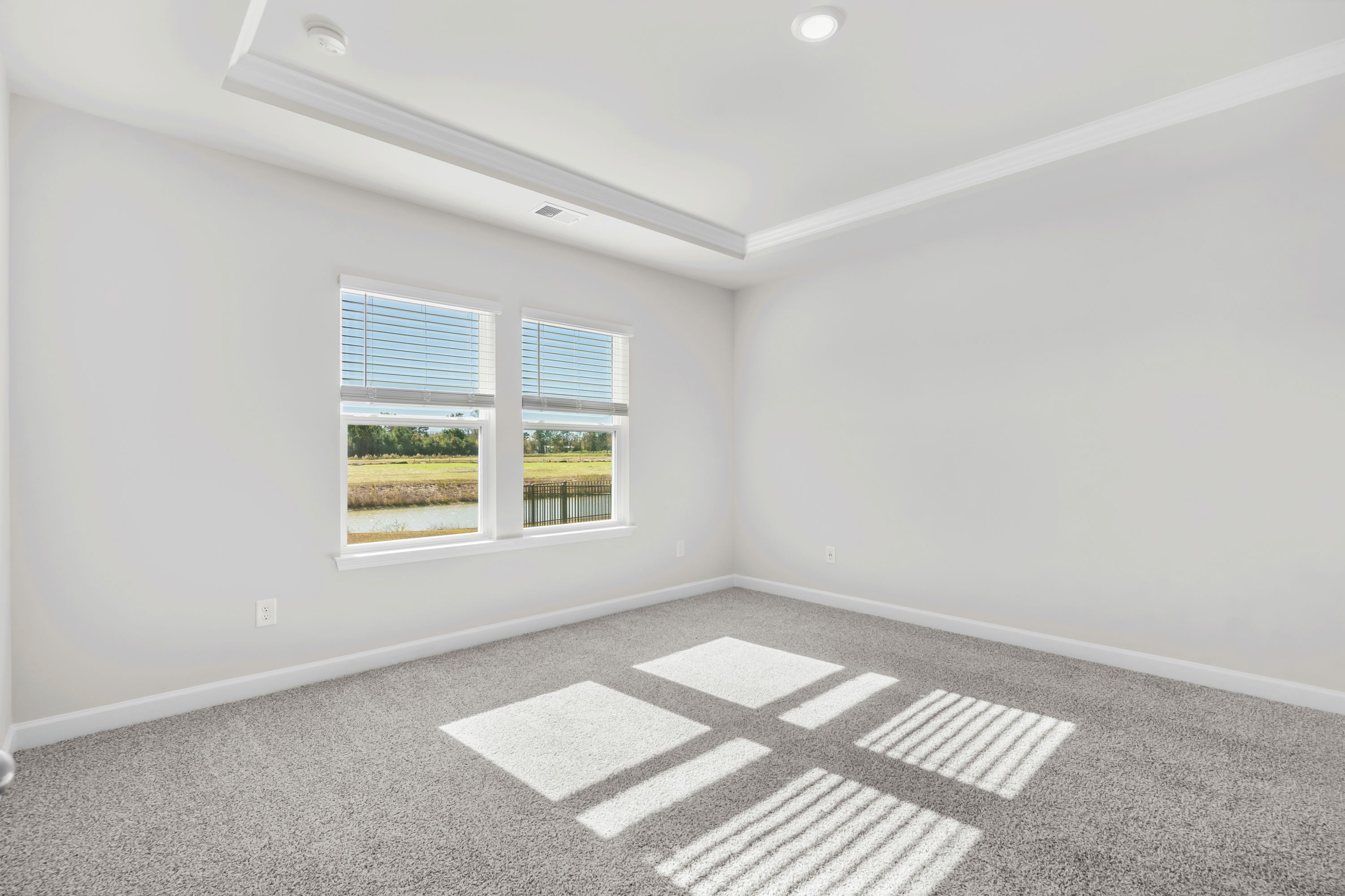 A private primary bedroom is accentuated with a tray ceiling.