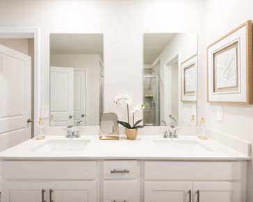The ensuite bathroom features dual-vanity sinks and a walk-in closet.